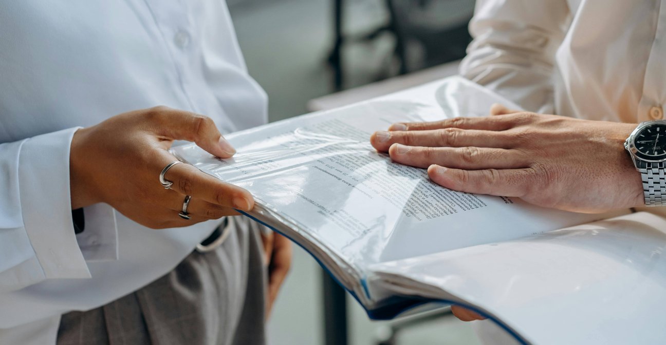 Muž s ženou prohlížející dokumenty v deskách